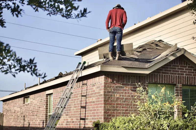 Professional roofer working on a residential roof in Uttsville